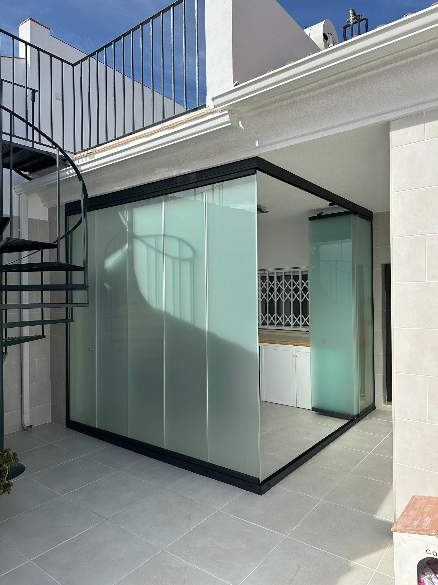 Cerramiento de balcón con sistema corredera de aluminio gris oscuro. Soluciones duraderas para empresas y particulares
